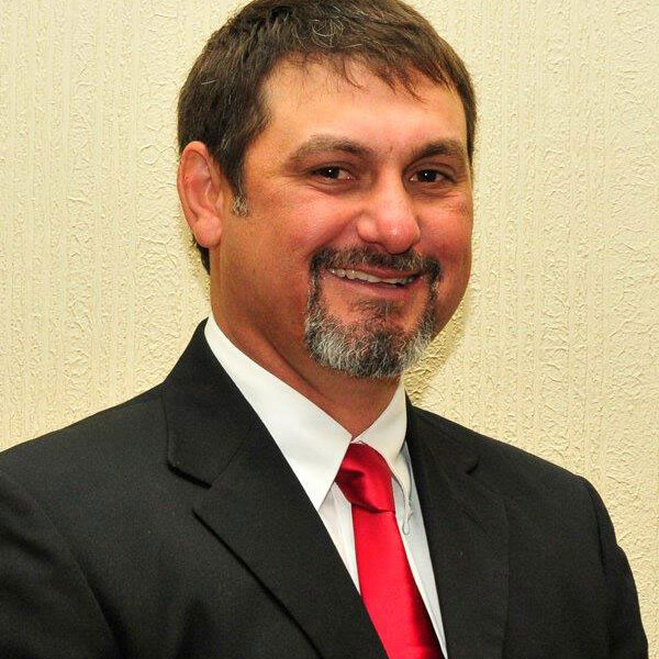 A man in a suit and red tie.