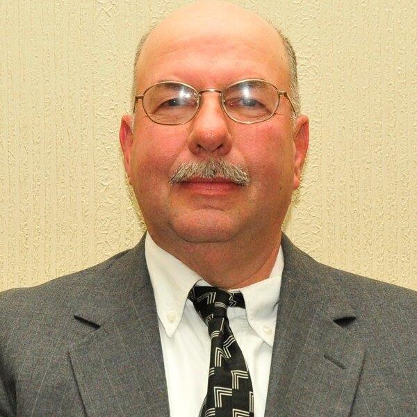 A man in a suit and tie wearing glasses.